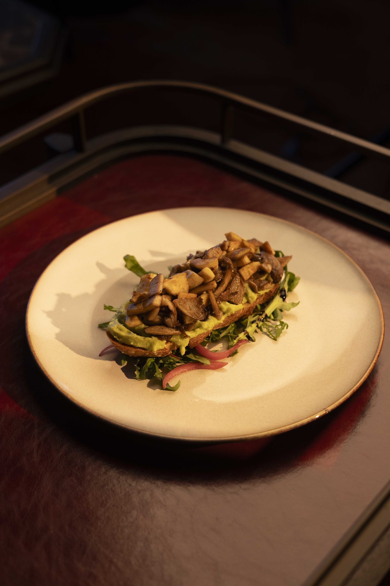 Mushrooms and greens plated on cream ceramic