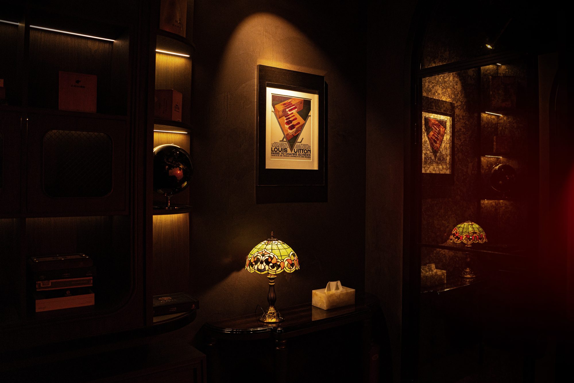 Low table lamps and framed prints in a dim corner of the dining room