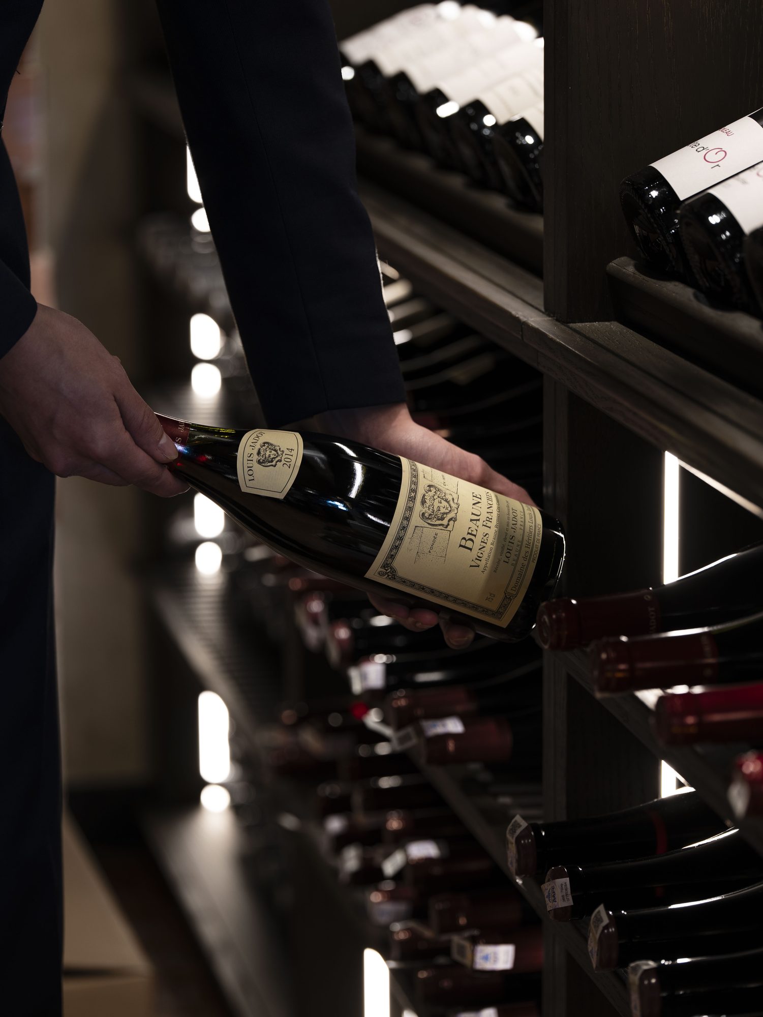A bottle of red standing in a pool of light